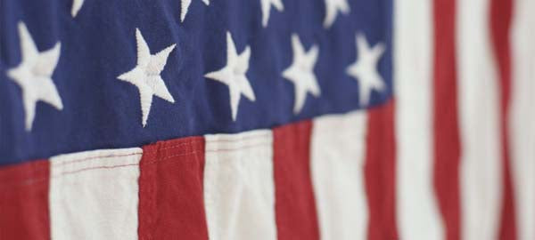 Close-up of the American flag showing stars on a blue background and red and white stripes.