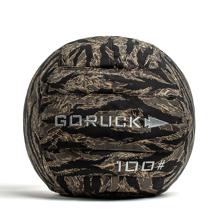 The Sand Medicine Ball by GORUCK is designed with a camouflage pattern and "100#" marking, making it ideal for boosting core stability during your home gym workouts.