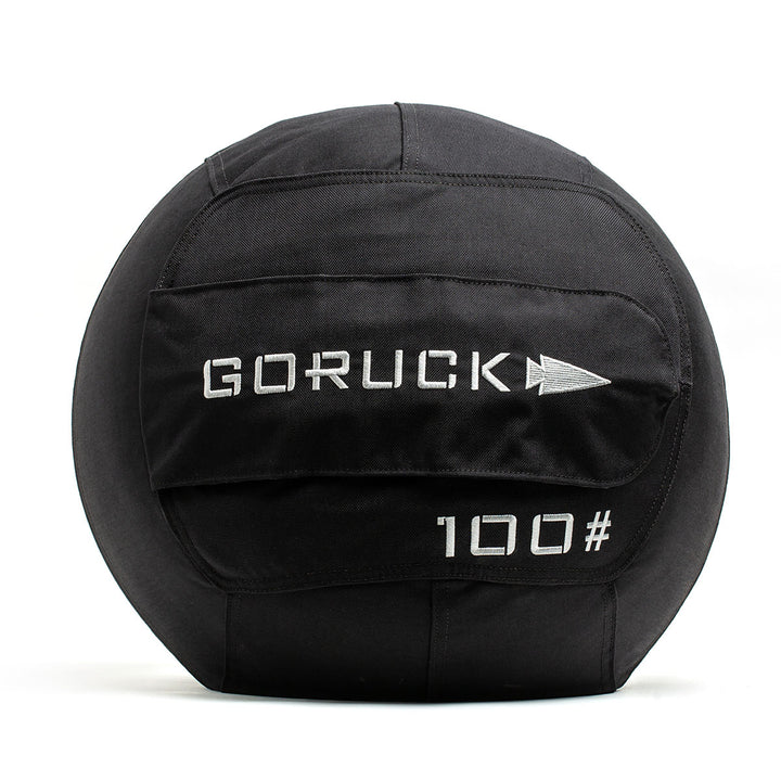 Black GORUCK Sand Medicine Ball with a "100#" label on the front, ideal for enhancing core stability in your home gym.