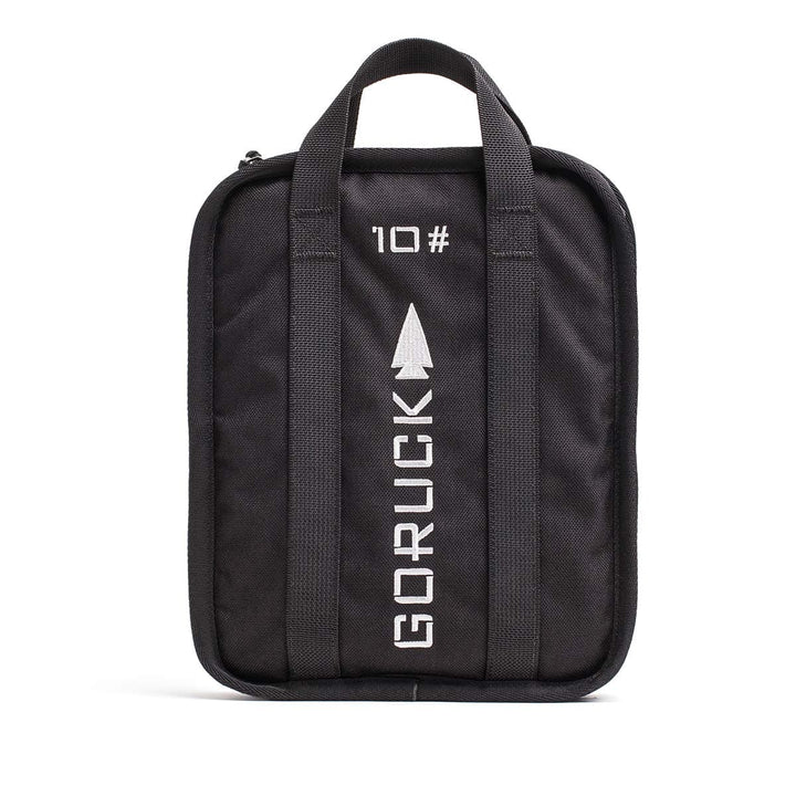 Black GORUCK bag with handles, showcasing a text and arrow design on the front, ideal for transporting your Sand Ruck Plates during rucking adventures.