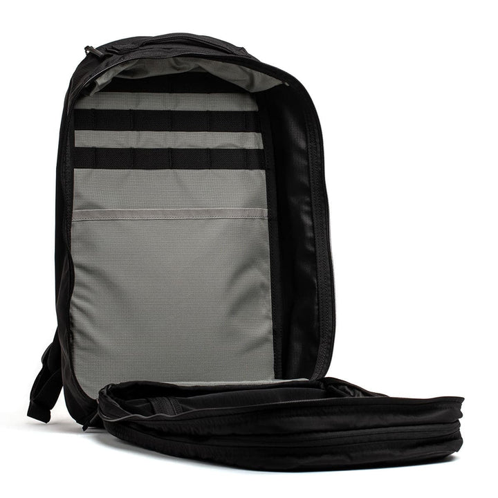 Open the GORUCK Bullet Ruck Double Compartment in ripstop nylon, featuring dual gray inner compartments and sturdy black straps.