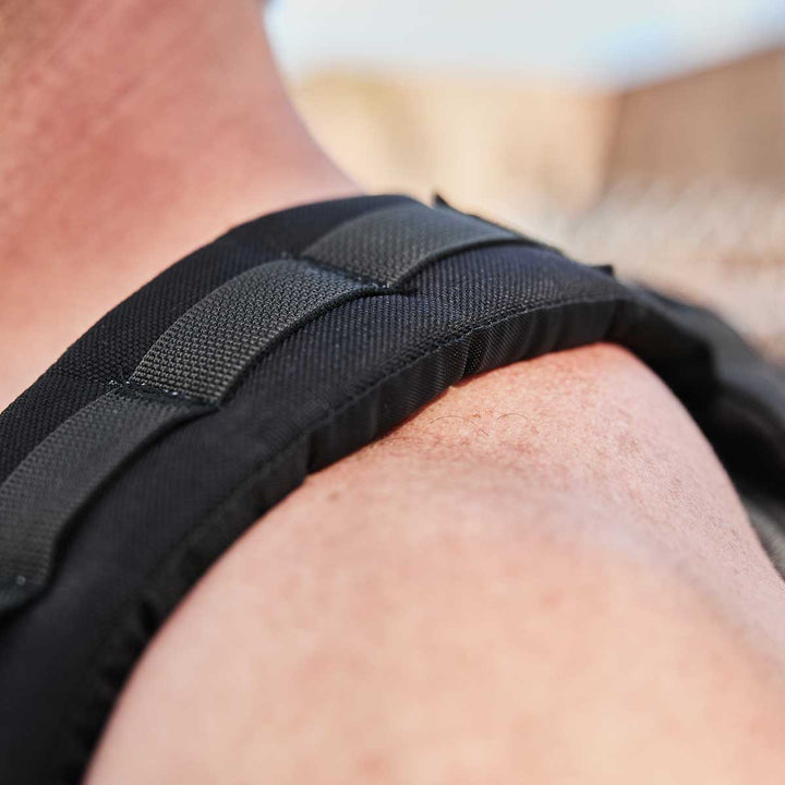 A close-up of a person's shoulder wearing the strap of a GORUCK GR1 USA backpack crafted from 210D CORDURA in black.