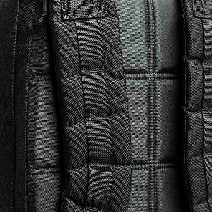 A close-up of the GORUCK GR1 USA backpack showcases its padded straps and quilted back panel, crafted from durable 210D CORDURA material.