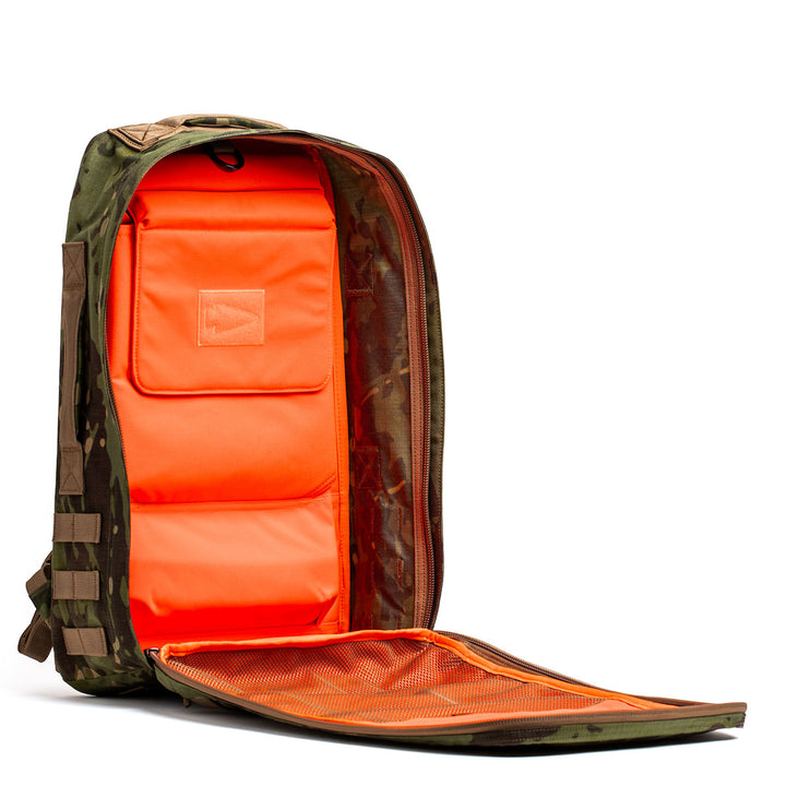 Unzip the GORUCK Rucker 4.0 camouflage backpack to reveal its bright orange interior and mesh pocket on the inside flap, making it ideal for rucking adventures.