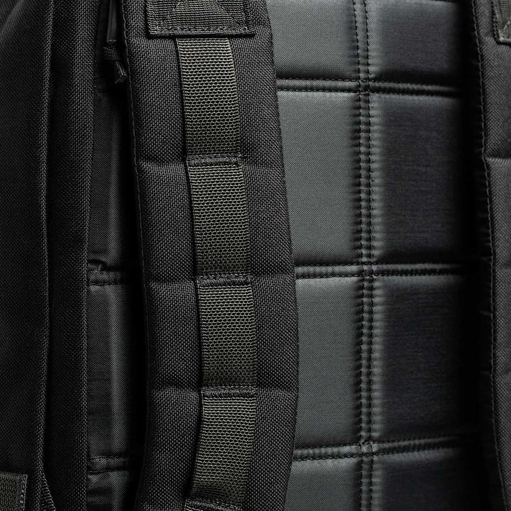 Close-up of a black and dark green quilted fabric featuring stitched straps, likely part of the GR2 - USA backpack by GORUCK, crafted from durable 210D CORDURA® and designed to be carry-on compliant for modern travelers.