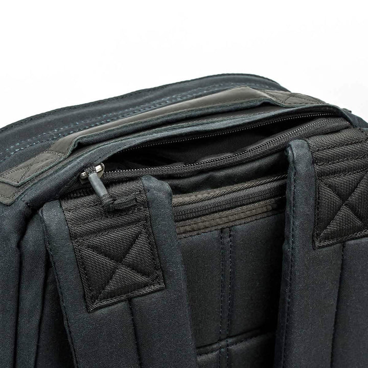 Close-up of the GR1 USA - Heritage rucksack by GORUCK with a zippered pocket and padded shoulder straps, made from durable waxed canvas in heritage black.