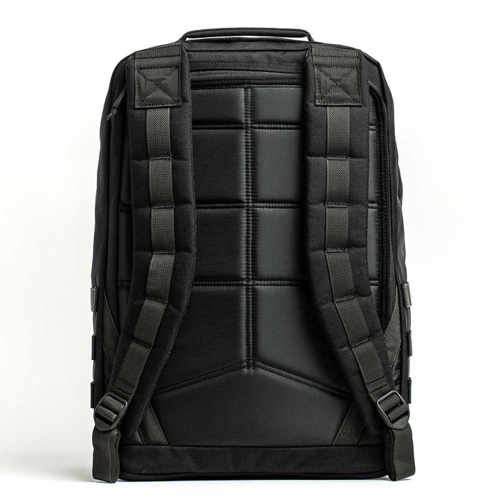 The GORUCK GR2 - USA backpack, made from 210D CORDURA® in black, showcases a sleek design with padded shoulder straps and a quilted back viewed from behind. Its carry-on compliance makes it an ideal choice for travelers who prioritize both functionality and style.