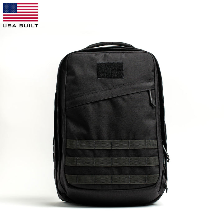 The GR2 - Cordura by GORUCK is a sleek, black tactical backpack with a minimalist design. It features a top handle, multiple compartments, and horizontal strap detailing on the front, inspired by Special Forces ruck gear. The backpack stands upright against a plain white background.