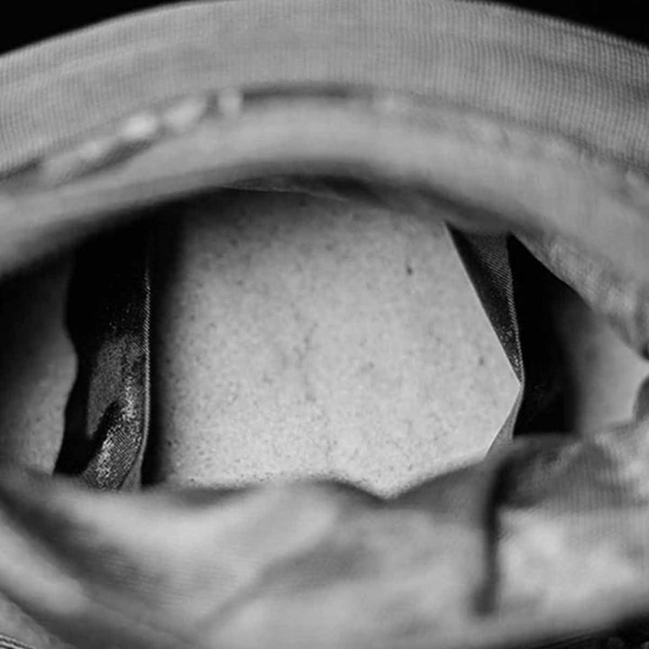 A close-up black and white image unveils the intricate multilayer closure system inside a hat, showcasing the fabric lining and part of the brim. The focus is on the textures and shapes within its interior, comparable to a finely designed GORUCK Sand Tombstones.