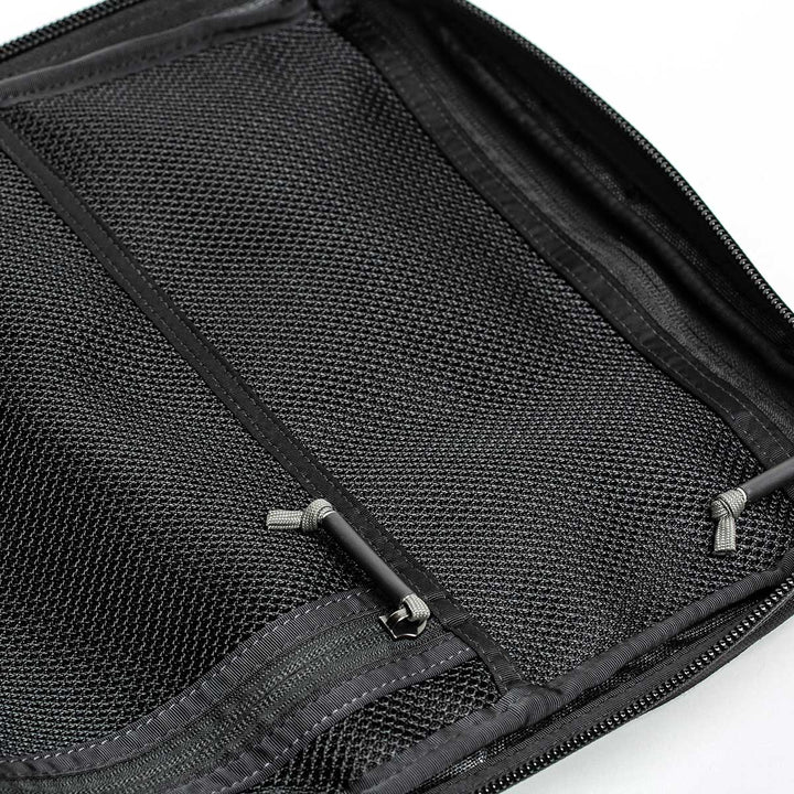 Close-up of the GORUCK GR2 - USA, featuring a rugged design with black mesh fabric, zippers, and visible seams. This perfectly carry-on compliant rucksack is crafted for durability and comes with our Scars Lifetime Guarantee, ensuring it stands the test of time and adventure.