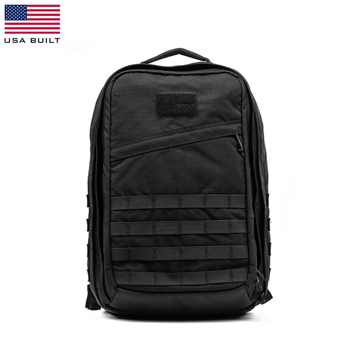 The GR2 by GORUCK is a black tactical backpack designed with Special Forces quality. It includes multiple compartments, a front zipper pocket, horizontal webbing, and a top carry handle. Its rugged design makes it perfect for outdoor adventures and it's also carry-on compliant. The background remains plain white.