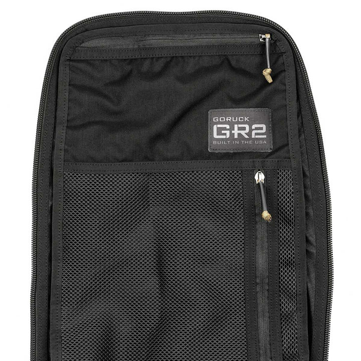 The black rucksack interior features mesh pockets and prominently displays a "GR2 - USA" label, branded by GORUCK, making it an ideal carry-on compliant companion with the assurance of the Scars Lifetime Guarantee.