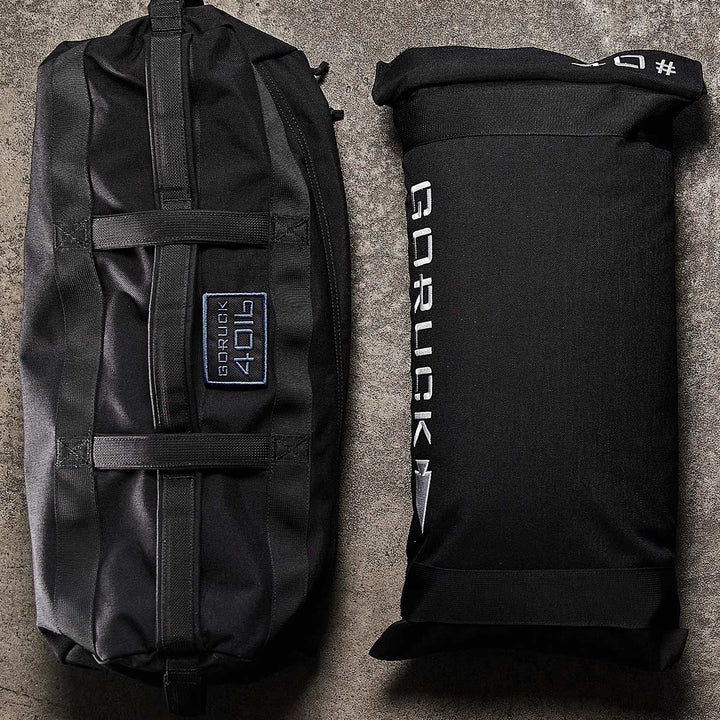 GORUCK Sandbag Kit (w/ Filler Bag) displayed on a textured surface, featuring heavy-duty handles and gear, promises durability with the Scars Lifetime Guarantee.