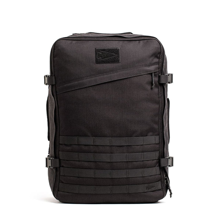 A black rectangular-shaped tactical backpack, the GR3 - Cordura from GORUCK, includes multiple compartments, adjustable side straps, and a small logo patch on the top front. Its water-resistant design features front horizontal webbing for attaching gear or accessories.