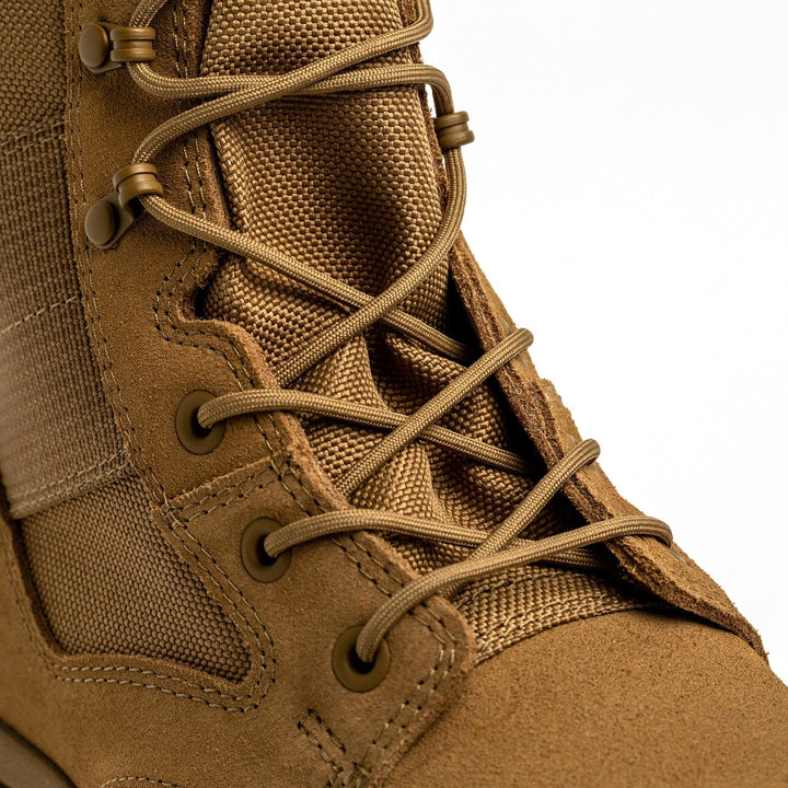 Close-up image of the GORUCK MACV-2 - High Top in Coyote, featuring detailed stitching and metal eyelets. The texture of the suede and fabric materials showcases its rugged design, enhanced by a triple compound outsole for improved traction.