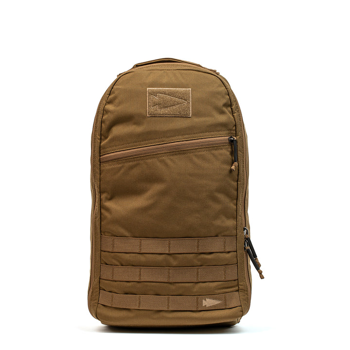 The GORUCK Bullet Ruck Laptop - 16L in Brown includes a bombproof laptop compartment, multiple compartments, MOLLE webbing on the front, and provides lumbar support for comfort during long travels.