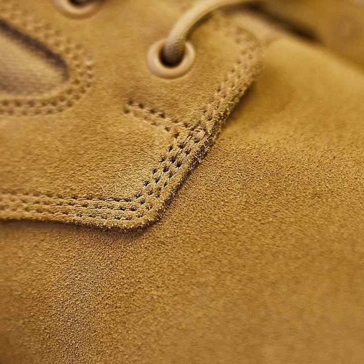 Close-up of tan suede material with detailed stitching and lacing, possibly from the AR670-1 compliant MACV-1 Hi-Speed - High Top boots by GORUCK, renowned for their lightweight design.