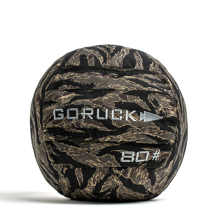 A black Sand Medicine Ball by GORUCK, featuring a handle, is perfect for boosting core stability at home. The ball is marked with the brand name GORUCK and the number 80# in white text, making it a versatile piece of equipment for your home gym collection.