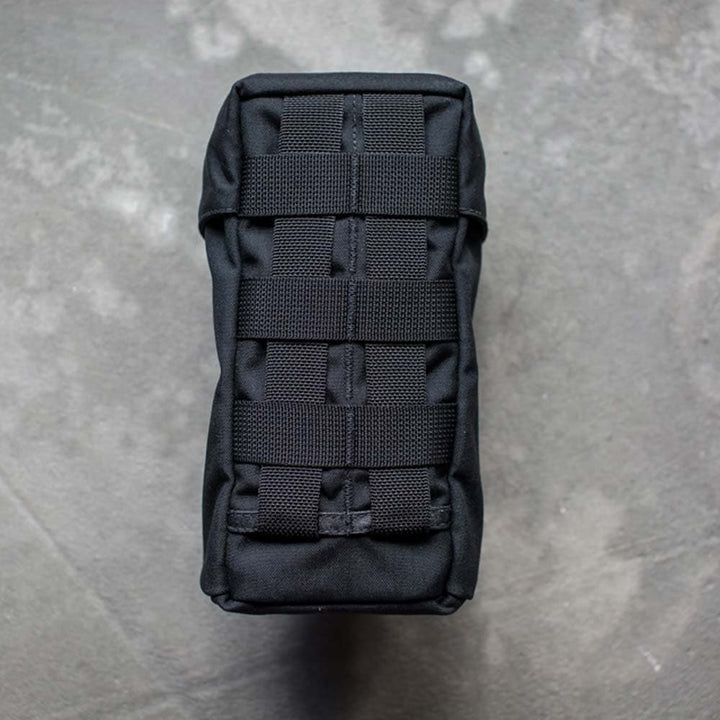 GORUCK Full Panel Water Bottle Pocket with MOLLE attachment system, viewed from above, on a gray textured surface.