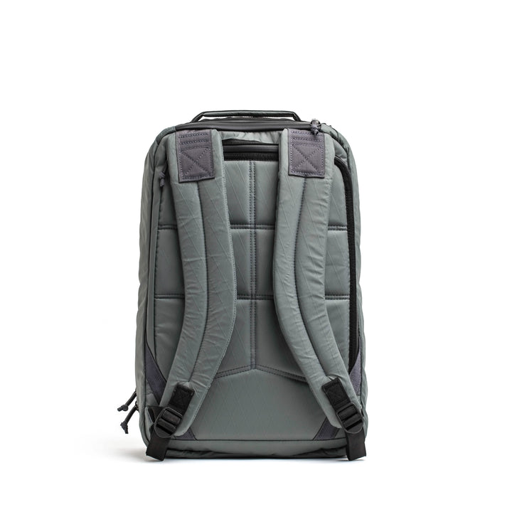 The GORUCK GR1 USA - X-PAC backpack in gray features padded straps, a quilted design, and AquaGuard zippers for enhanced protection, shown from the back.