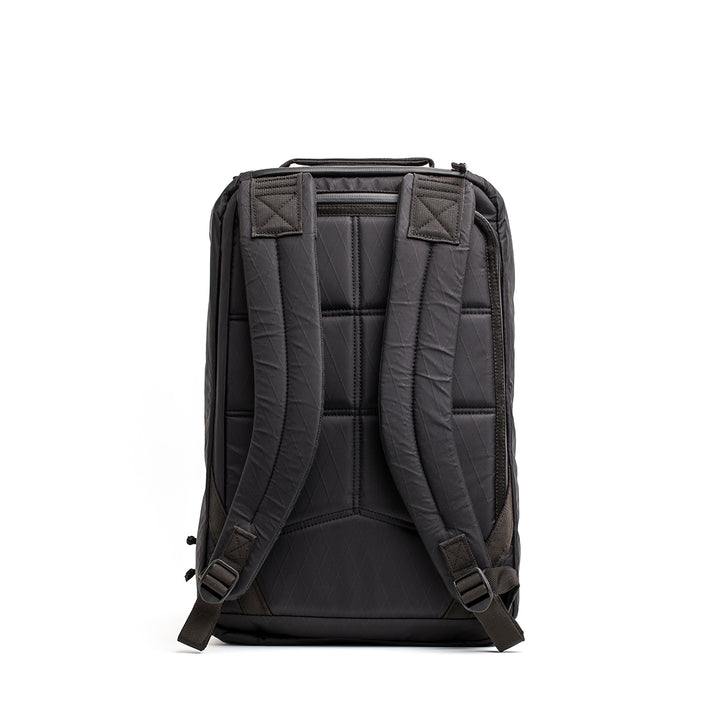 The back view of the GR1 USA - X-PAC backpack by GORUCK showcases its padded straps and AquaGuard zippers set against a white background.