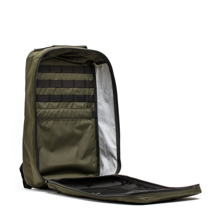 Open the olive green GR1 USA - X-PAC backpack by GORUCK, which includes multiple interior pockets and compartments and features AquaGuard zippers for improved water resistance.