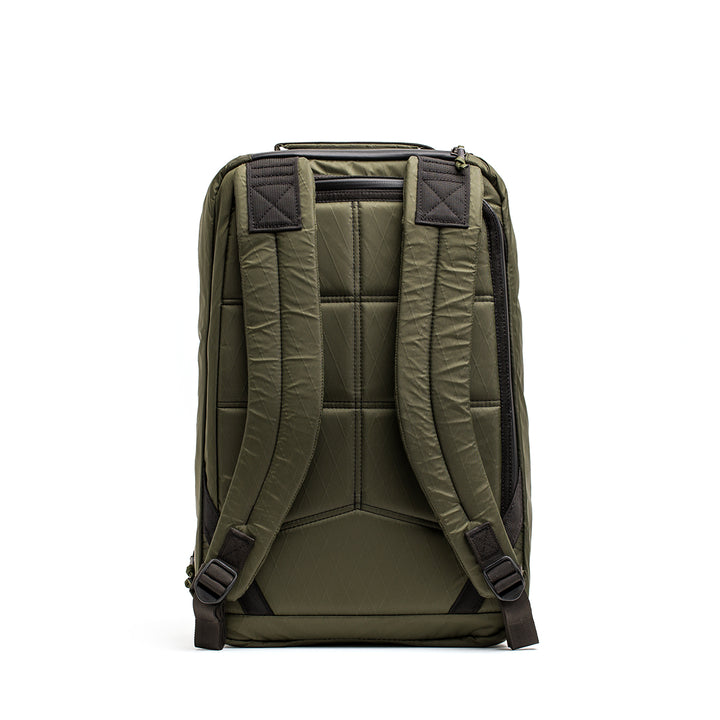 The GR1 USA - X-PAC by GORUCK is a green backpack with a padded back, adjustable shoulder straps, and AquaGuard zippers for enhanced durability, displayed from the rear.