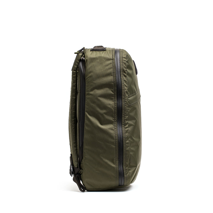 Side view of the GORUCK GR1 USA - X-PAC backpack in green, featuring waterproof AquaGuard zippers and adjustable straps.