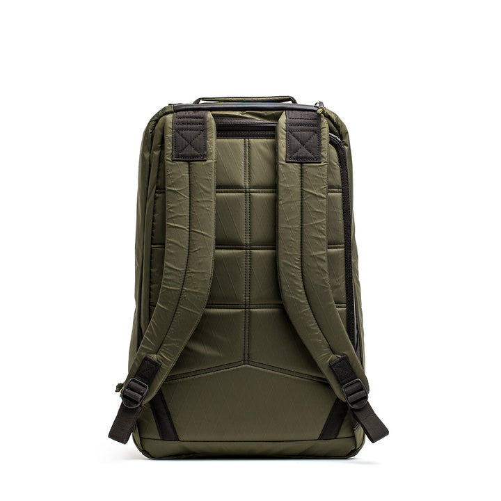 The GR1 USA - X-PAC by GORUCK is a green backpack with AquaGuard zippers, padded shoulder straps, and a quilted back design for comfort. Its waterproof build allows it to stand upright against a plain background.