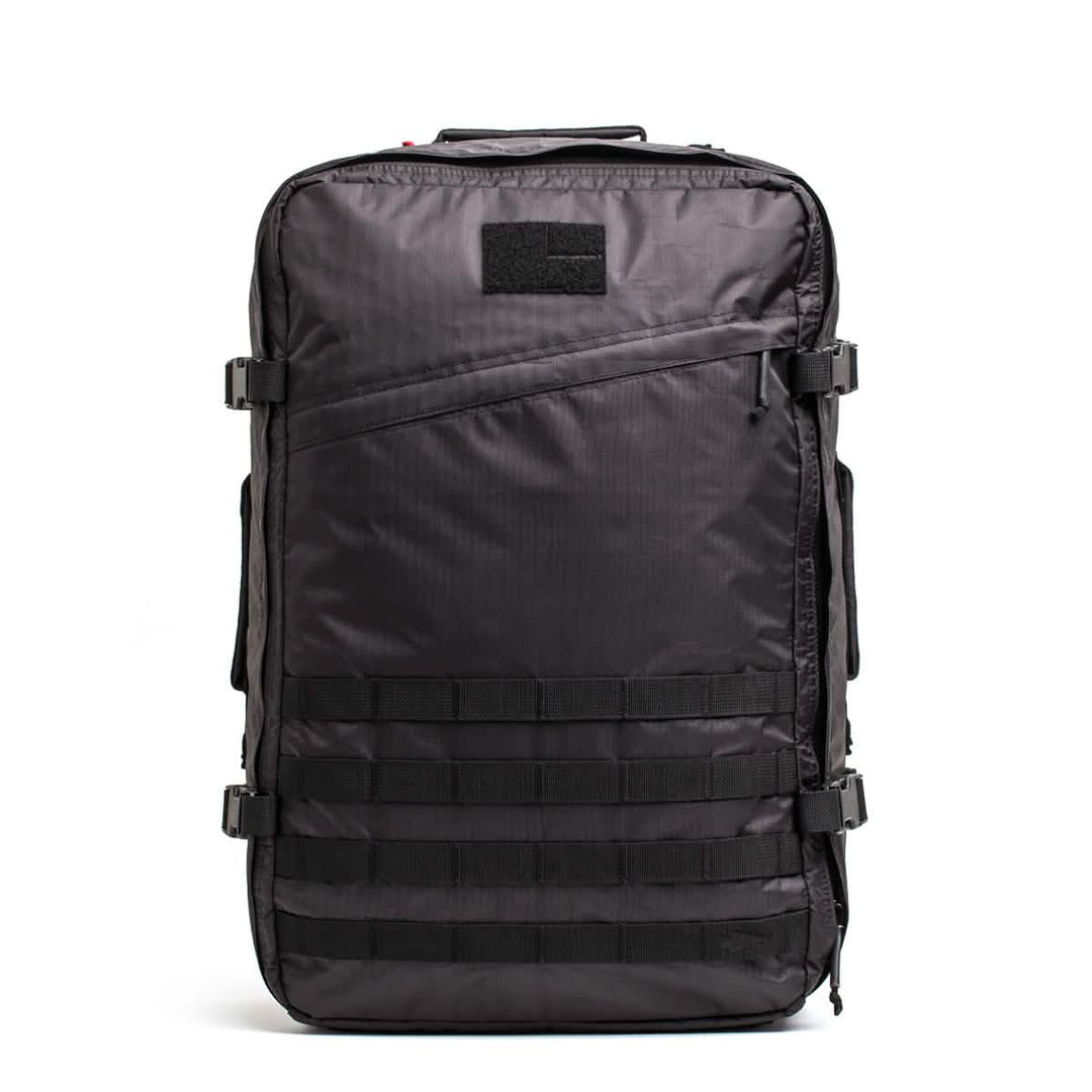 Introducing the GR3 - Dyneema by GORUCK: a black tactical carry-on backpack with a sleek rectangular shape and multiple compartments. It boasts adjustable straps, MOLLE webbing on the front, and a convenient small patch area at the top. Crafted with durable Dyneema material, this backpack is both stylish and functional for various outdoor activities.