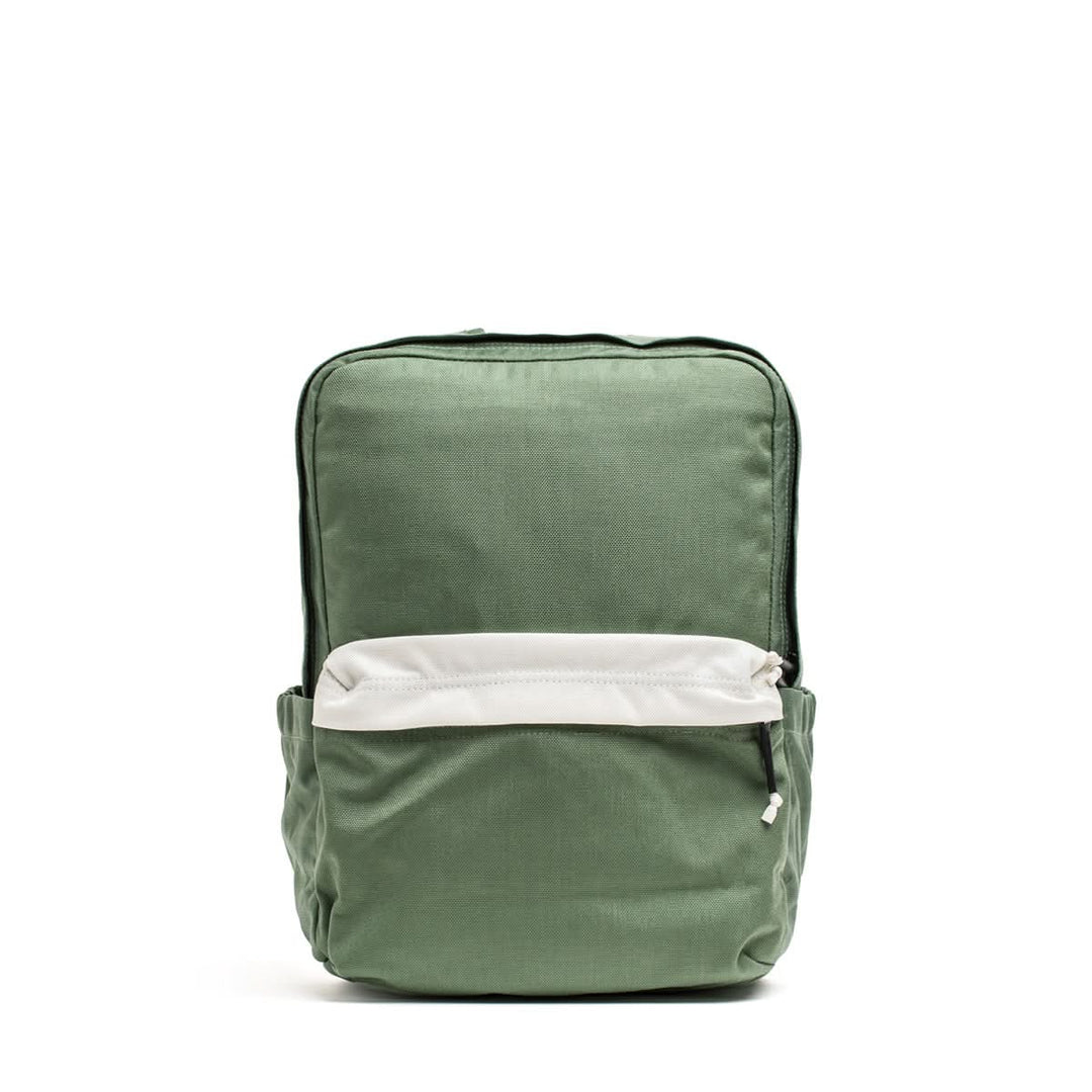 The KR1 2.0 - Kid Ruck by GORUCK is a simple green kids backpack with reinforced stitching, featuring a front white zipper pocket and side pockets, shown on a white background.