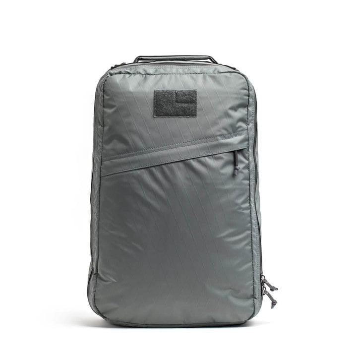 The GR1 USA - X-PAC by GORUCK is a sleek gray backpack with AquaGuard zippers, a front zipper pocket, and a top handle for added style and durability.