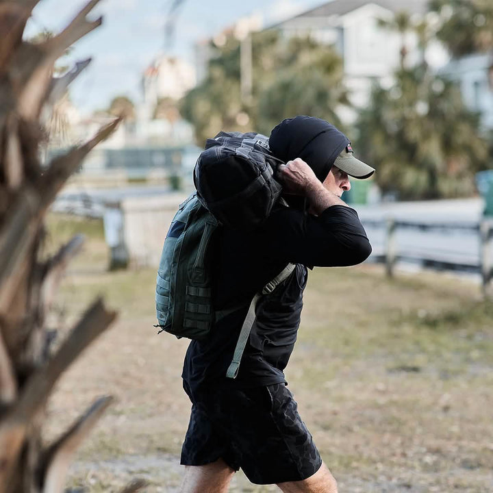 Man training with Rucksack and Sandbag in a Men's Sun Hoodie - ToughMesh in Black