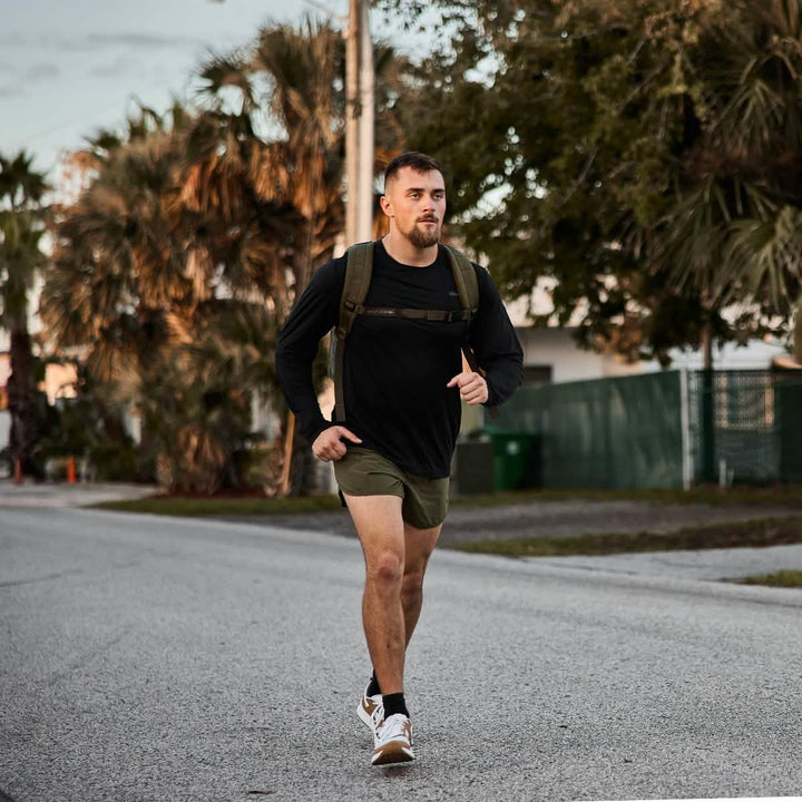 Man rucking outdoors. Man is wearing Men's Long Sleeve Performance Tee - ToughMesh Black