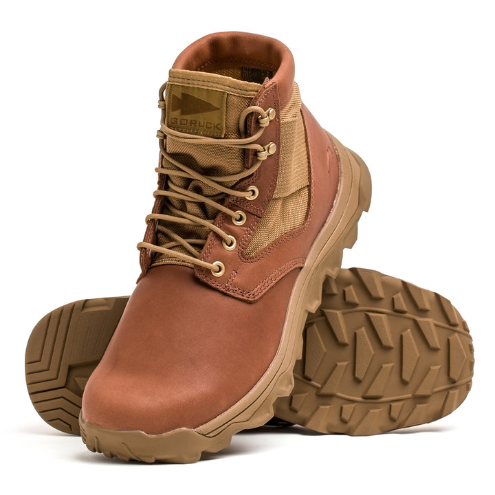 The MACV-2 Mid Top by GORUCK, in Briar + Coyote, are brown hiking boots with rugged soles, laces, and a side pocket. These jungle boots feature an aggressive triple compound outsole for conquering tough terrains easily.