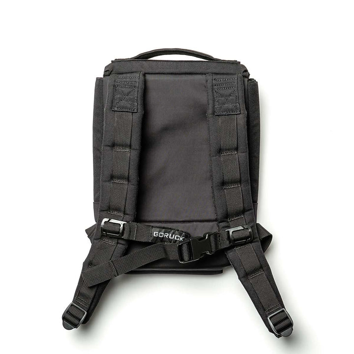 The Ruck Plate Carrier 3.0 by GORUCK is a black backpack made from durable 1000D CORDURA, featuring padded shoulder straps, a chest strap, and a carry handle. It is designed with ergonomic lumbar support and adjustable buckles to ensure a comfortable fit. The GORUCK brand label stands out near the bottom against a white background.