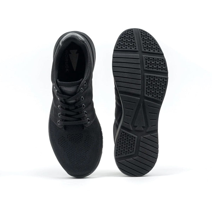 A pair of GORUCK Ballistic Trainers - Blackout + Black, featuring one shoe showcasing the side view and the other highlighting the 3X Support™ sole pattern.