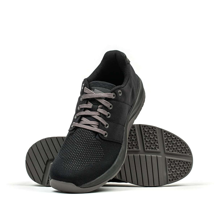 This black Ballistic Trainer by GORUCK, tailored for functional fitness enthusiasts, showcases charcoal laces and incorporates 3X Support™. Viewed from the front, you can also note the sturdy sole constructed with CORDURA® Ballistic Nylon for superior durability.