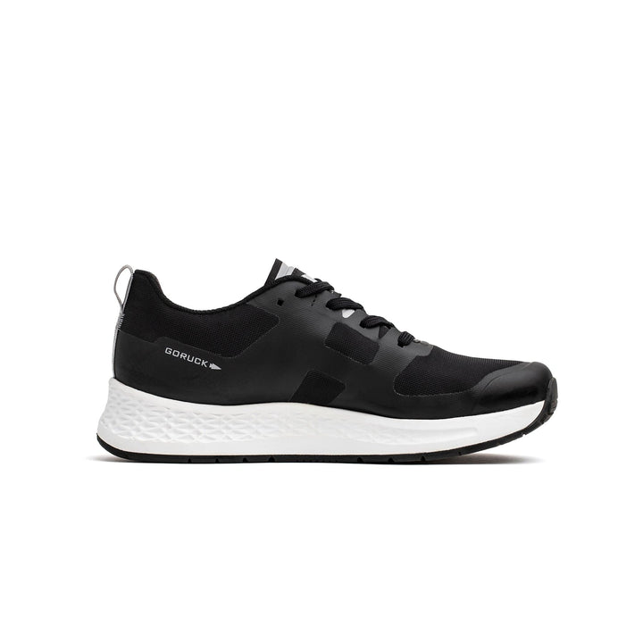 The Rough Runner - Black + White by GORUCK is an ultra-supportive running sneaker featuring a black and white design, a Gradient Density EVA midsole, and a sleek white sole, shown from the side view.