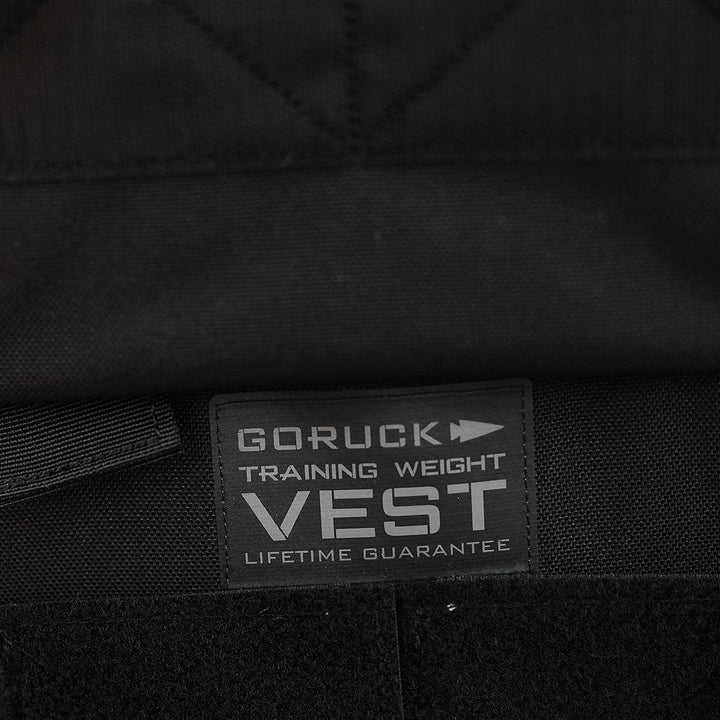 Close-up of a GORUCK Training Weight Vest 2.0 label highlighting the prominent "Lifetime Guarantee" text, engineered to endure the demanding use of Ruck Plates in strenuous workouts.