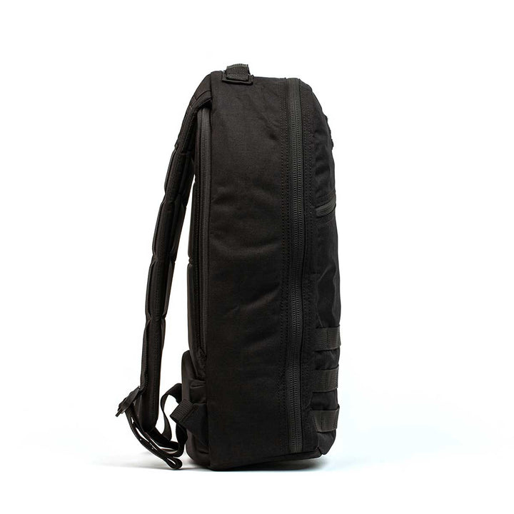 Side view of the GORUCK Bullet Ruck Laptop - 16L in black, featuring padded straps, lumbar support, and a zippered main compartment.