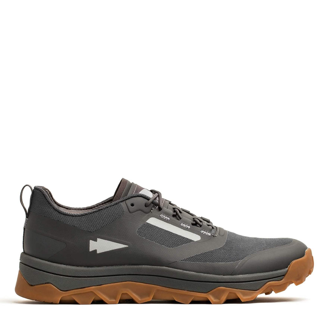 The GORUCK Mackall in Forged Iron, Chiseled Stone, and Gum is a gray and black trail running shoe with a brown sole, perfect for all-terrain rucking adventures.