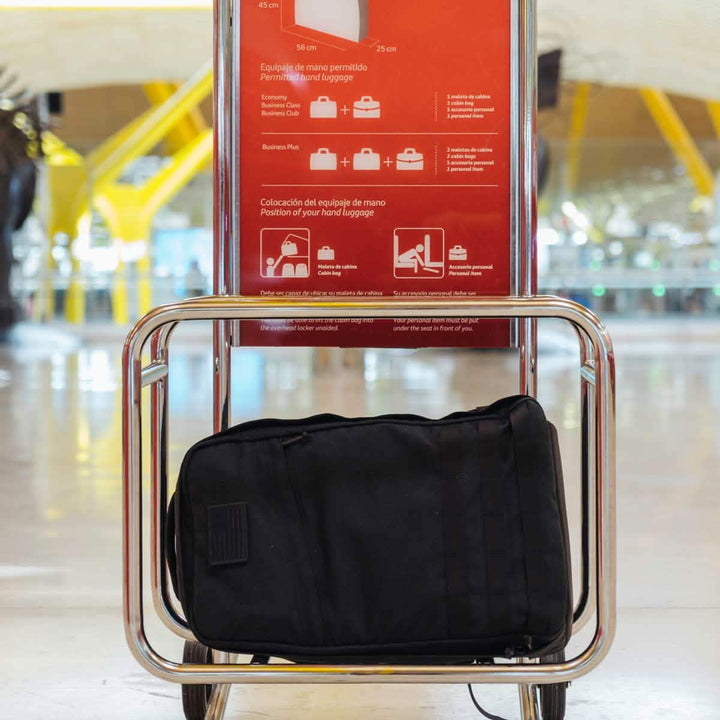 The sleek black GR1 USA rucksack from GORUCK fits effortlessly into the airport baggage checker, meeting all measurement guidelines with ease.