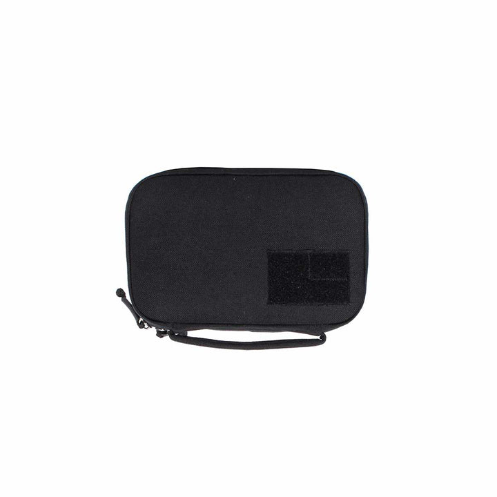 The GORUCK GR1 Field Pocket, with its sleek black rectangular design, comes equipped with a zippered closure, wrist strap, and front velcro patch, making it perfect for use as an electronics organizer.