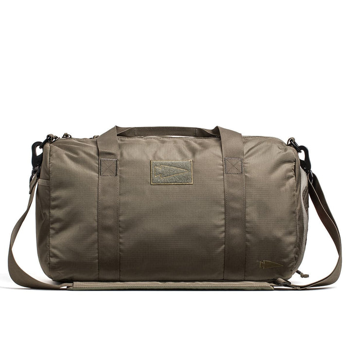 The GORUCK Gym Bag - Ripstop ROBIC® is a khaki-colored gym bag crafted from durable ripstop nylon, equipped with a shoulder strap, handles, and a convenient shoe compartment, displayed on a white background.