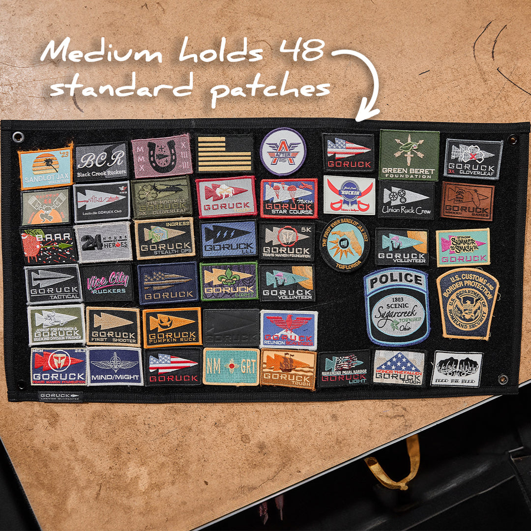 The GORUCK Spearhead Patch Board, made from durable black 1000D Cordura, displays 48 embroidered patches in neat rows. It features a secure velcro panel for easy patch attachment and arrangement, and holds "48 standard patches.