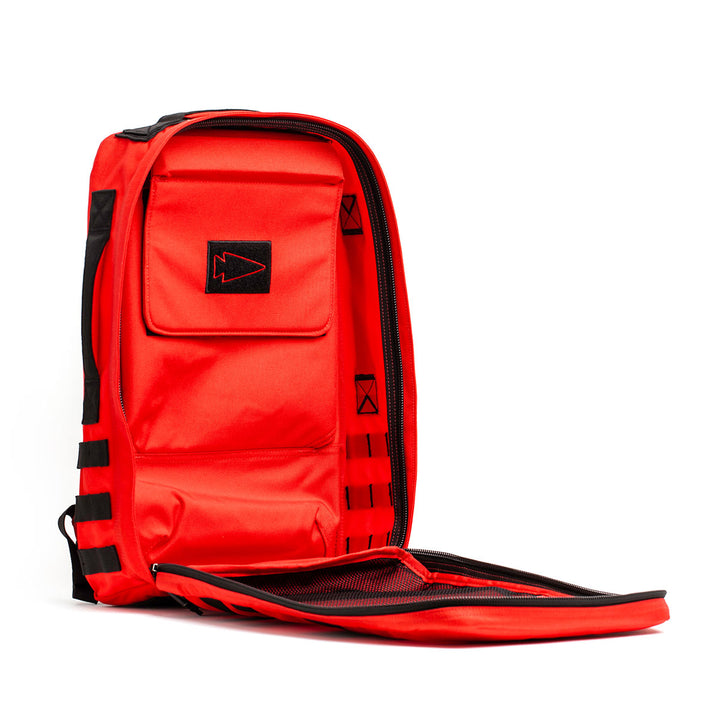 The GORUCK Rucker 4.0 backpack, showcasing a bold red and black design, includes an open front flap and numerous compartments, making it the ideal companion for rucking adventures. It's poised upright, prepared to handle any challenge that comes your way.