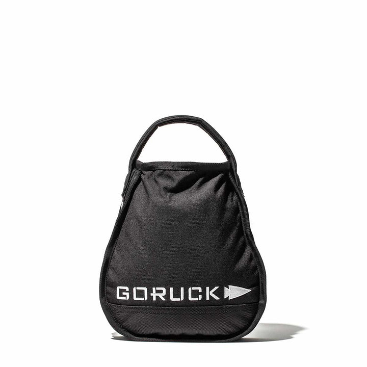 The GORUCK mini bag in black, crafted for durability, features a top handle and is styled elegantly on a white surface. It's ideal for carrying essentials or even fitting a Sand Kettlebell for your adventurous routines.