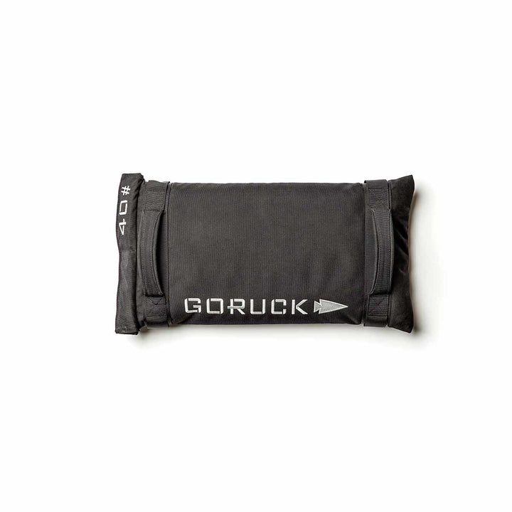 The GORUCK Simple Training Sandbags in black, ideal for your home gym, come with durable handles and feature the iconic logo set against a white background. They are constructed to endure with the Scars Lifetime Guarantee.