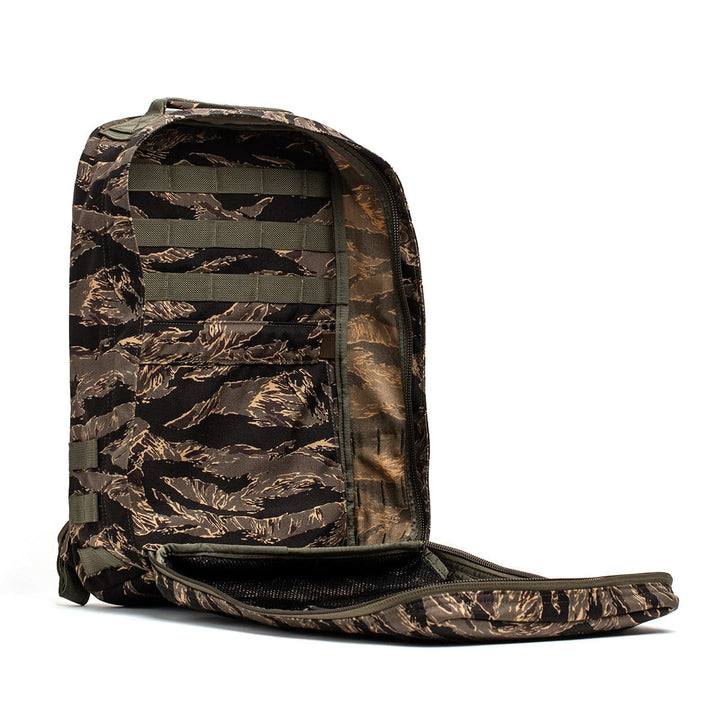 The GR1 USA rucksack by GORUCK, featuring a camouflage design with visible compartments and crafted from durable 210D CORDURA, is displayed against a white background.